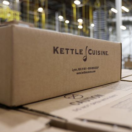 Stacked cases of Kettle Cuisine carrot ginger soup on the production floor