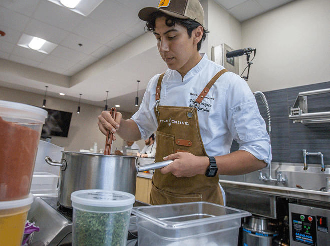 A Kettle Cuisine culinary specialist stirring a pot in the innovation kitchen