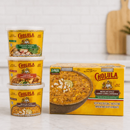 Cholula heat-and-eat soup tubs stacked beside a Mexican street corn chowder carton