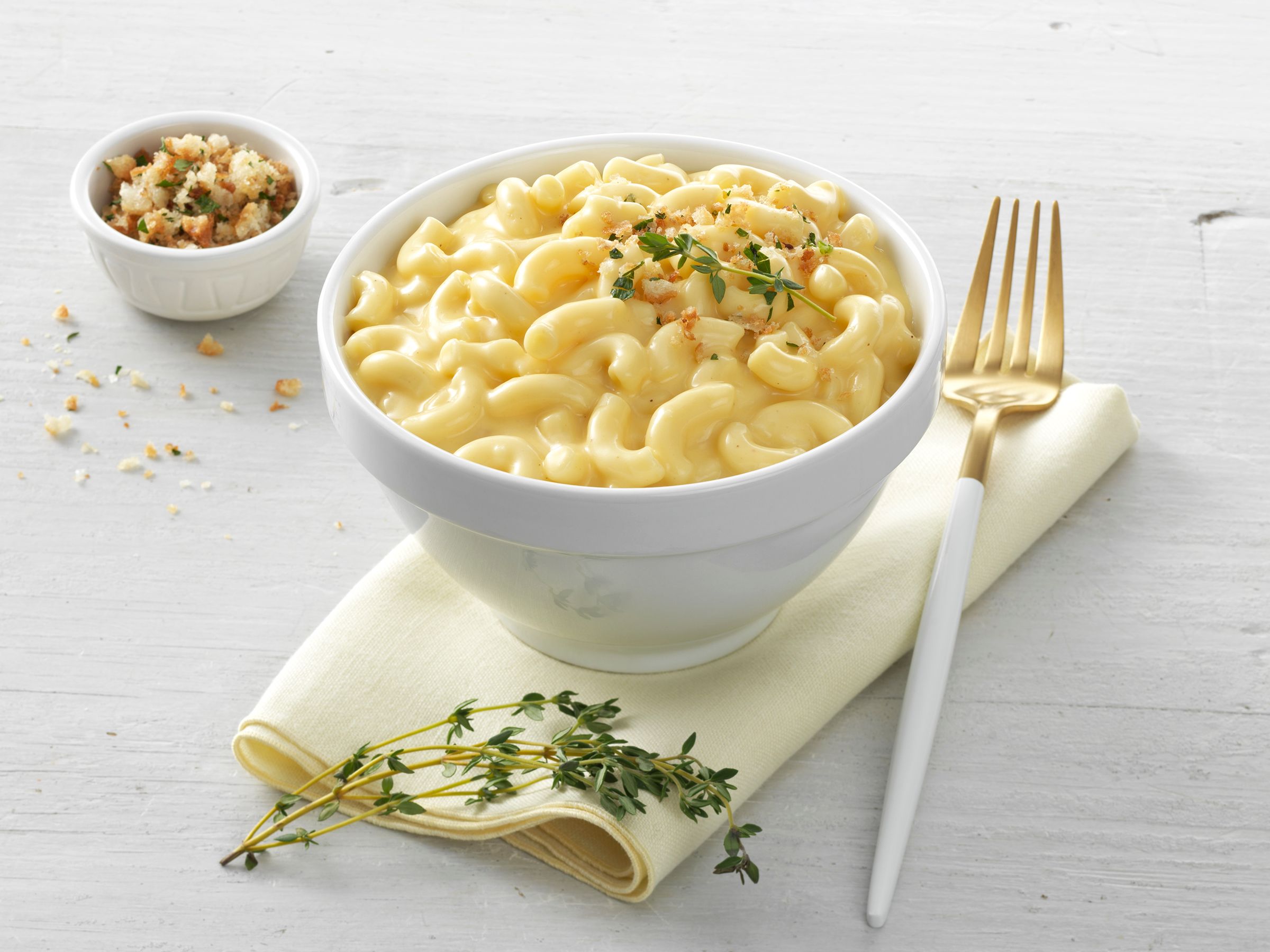 A bowl of macaroni and cheese topped with herbed breadcrumbs